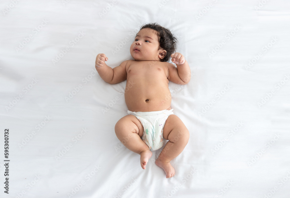 Portrait Asian Newborn baby girl wear diapers sleep on a soft white bed. cute infant isolated