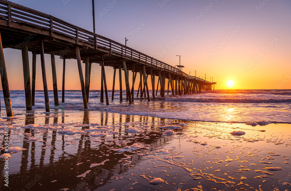 Venerable wood fishing pier in Virginia Beach at sunrise.