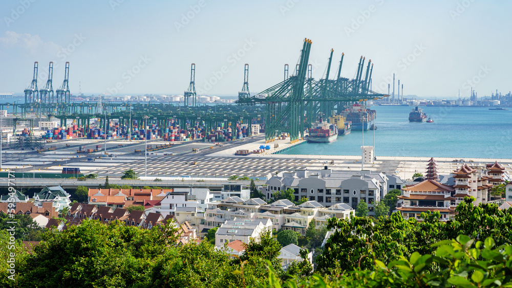 The cranes in the port of Pasir Panjang unloading containers from cargo ships passing by Singapore o