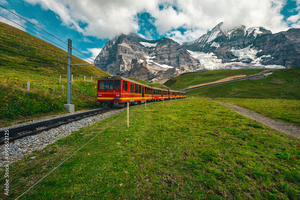 Electric tourist cogwheel train on the green slope in Switzerland