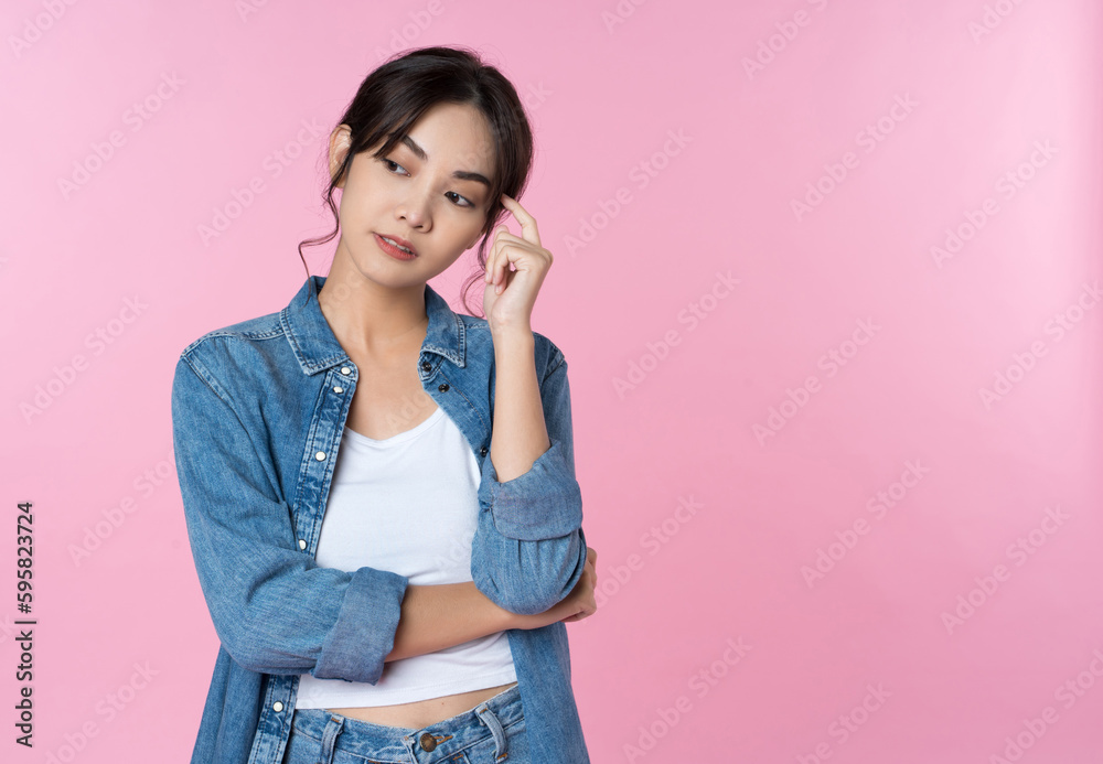 Young Asian woman woman thinking and imagination isolated over pink background. Think idea solution 