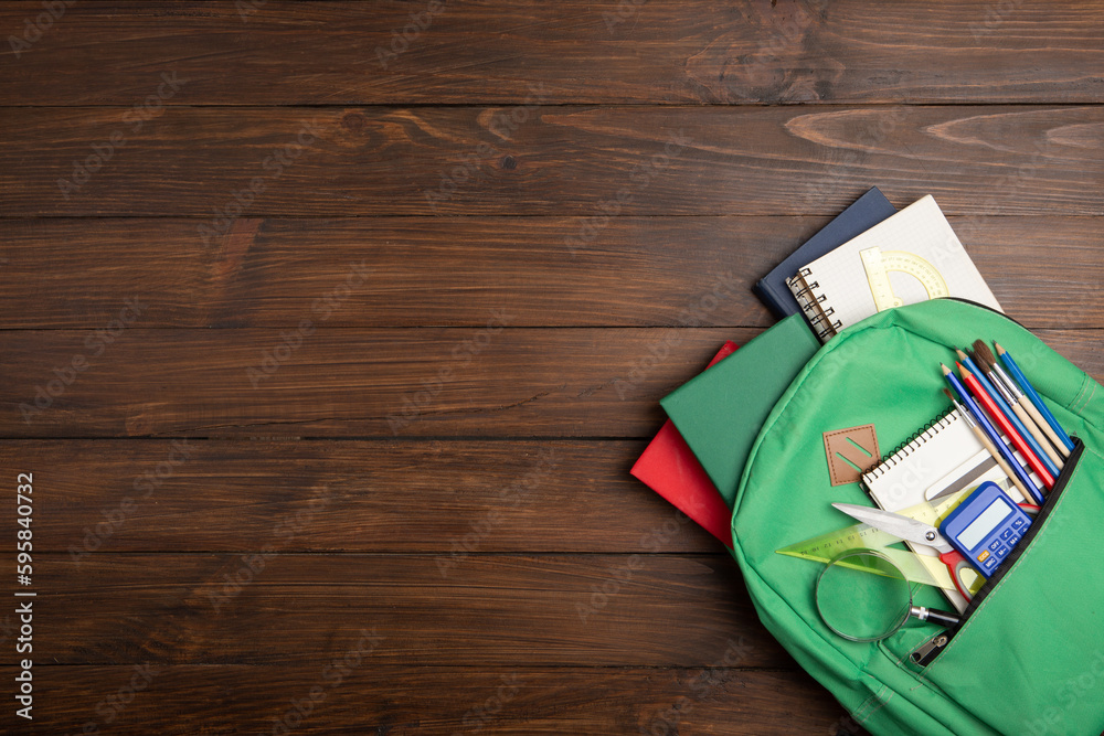 Back to school - books and school backpack on the desk in the auditorium, Education concept.