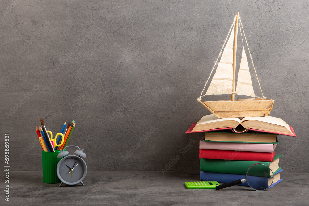 Education is a journey concept, toy boat and books on the table, inspiration for a writing a fairy t