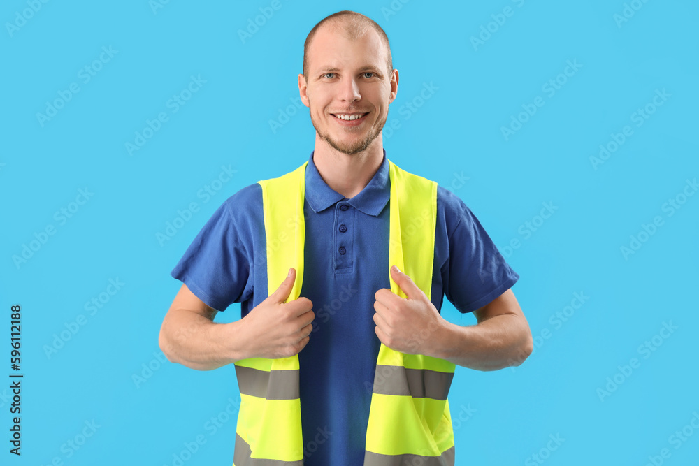 Male worker in vest on blue background