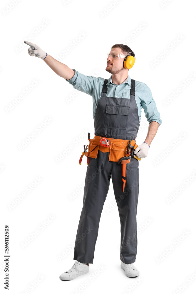 Male carpenter in hearing protectors pointing at something on white background