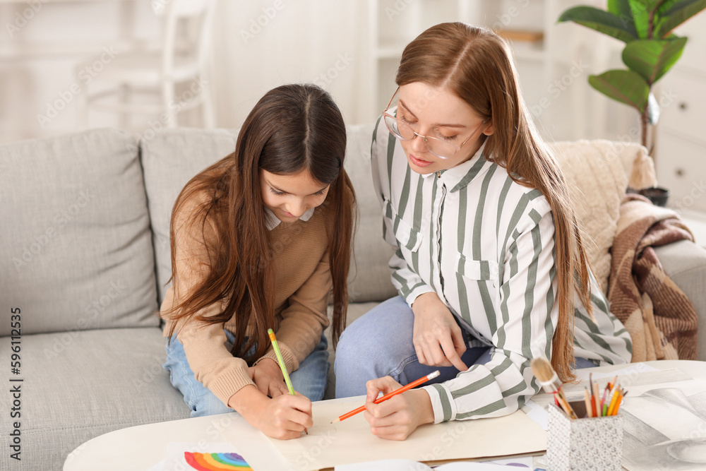 Drawing teacher giving private art lesson to little girl at home