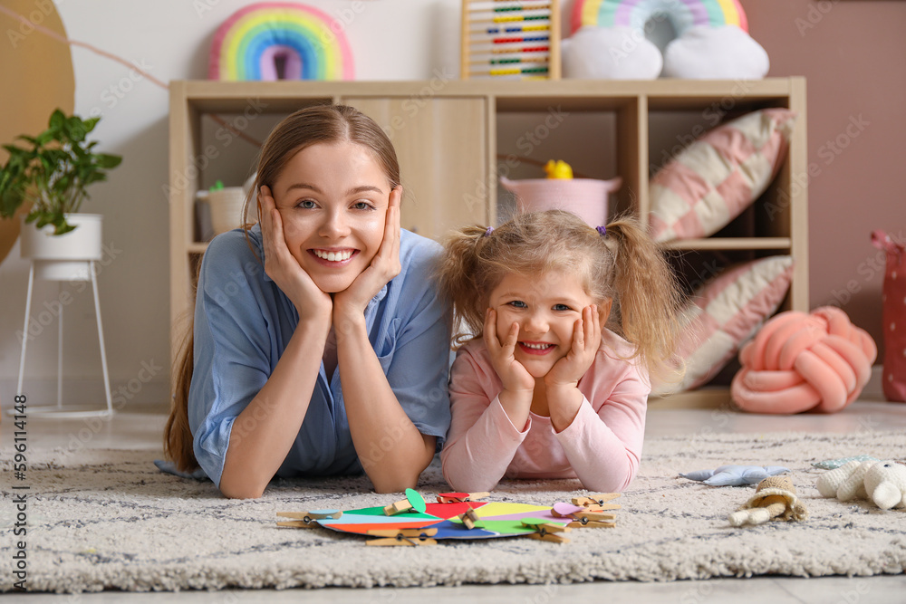 Cute little girl and her mother with matching game at home