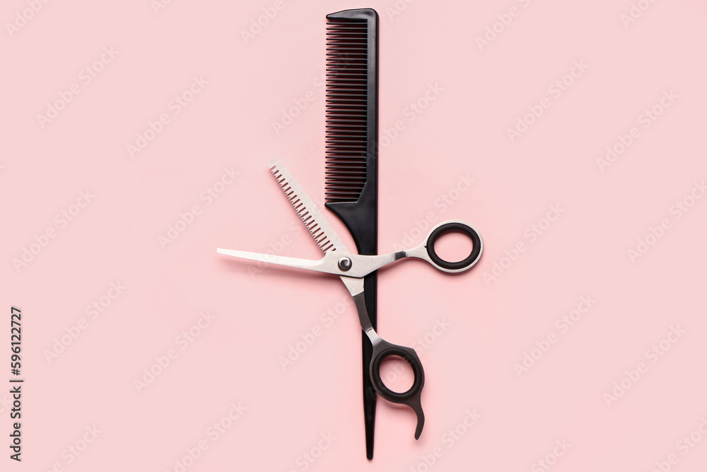 Hair comb with scissors on pink background