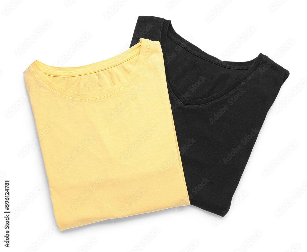 Folded yellow and black t-shirts on white background