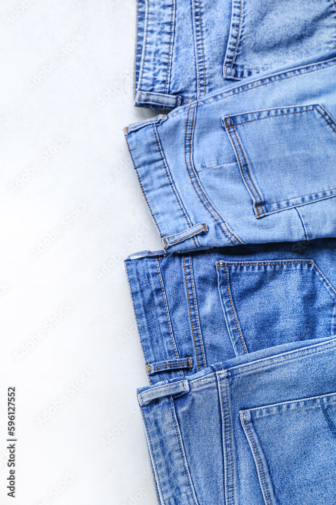 Stylish jeans on white background, closeup