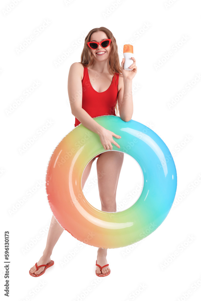 Beautiful young woman with sunscreen cream and inflatable ring on white background