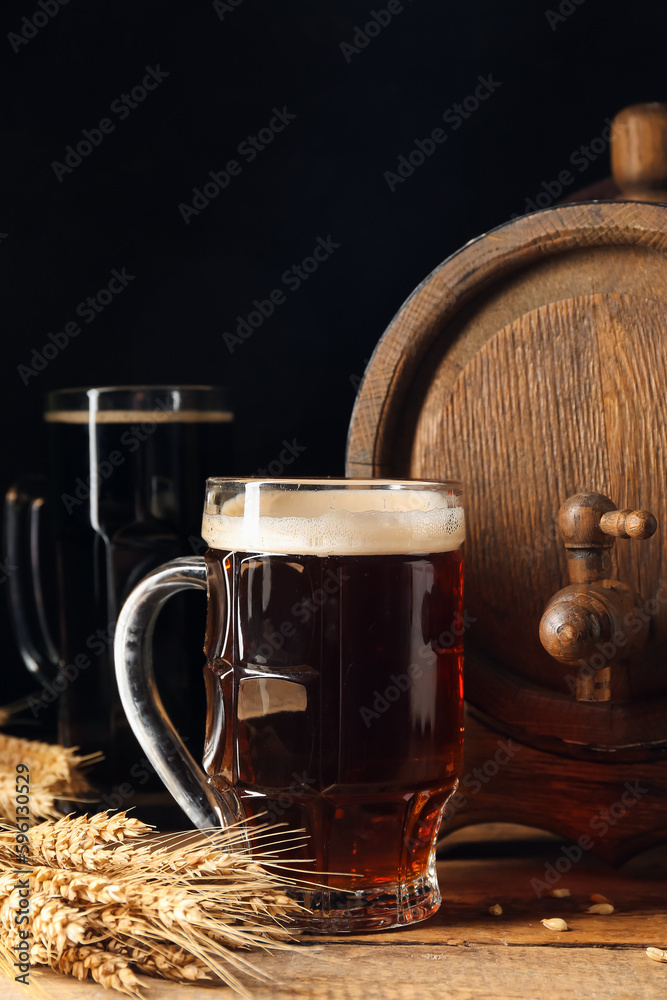 Wooden barrel and mug of cold beer on table against dark background