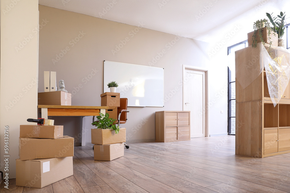 Workplace with cardboard boxes in office on moving day