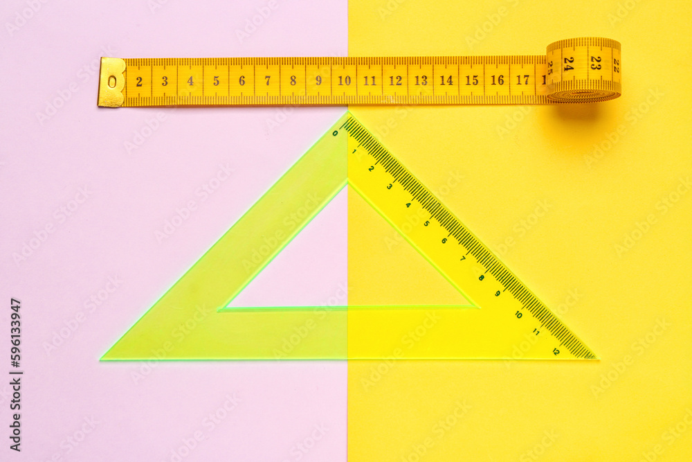 Triangle plastic ruler and measuring tape on color background