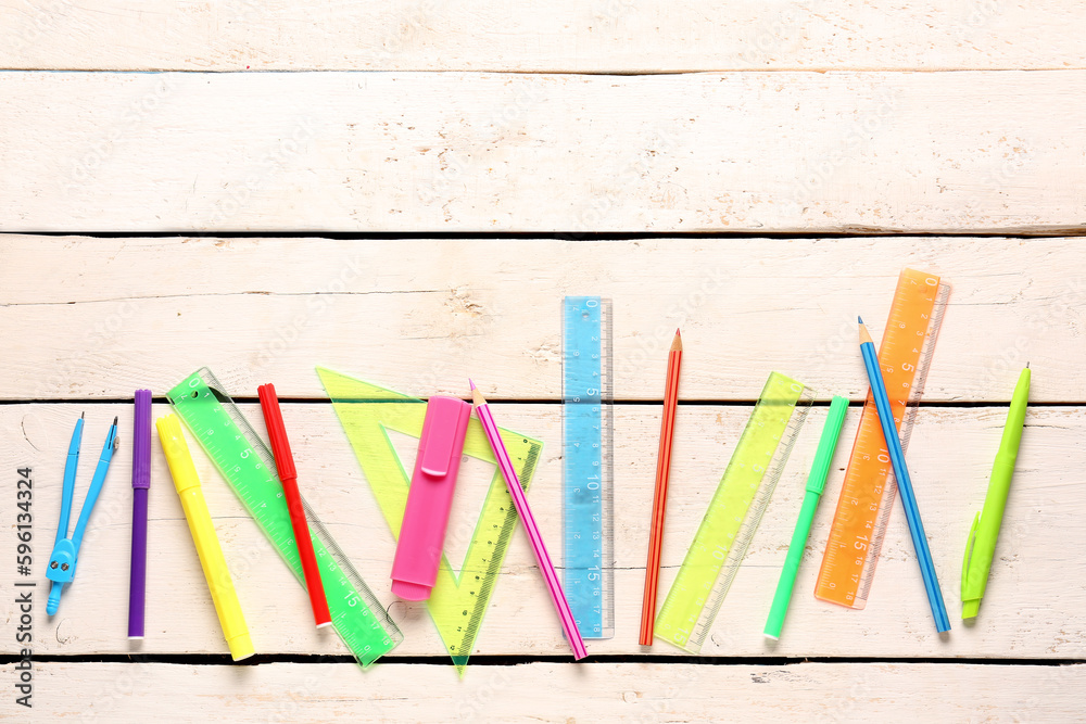 Colorful stationery supplies on light wooden background