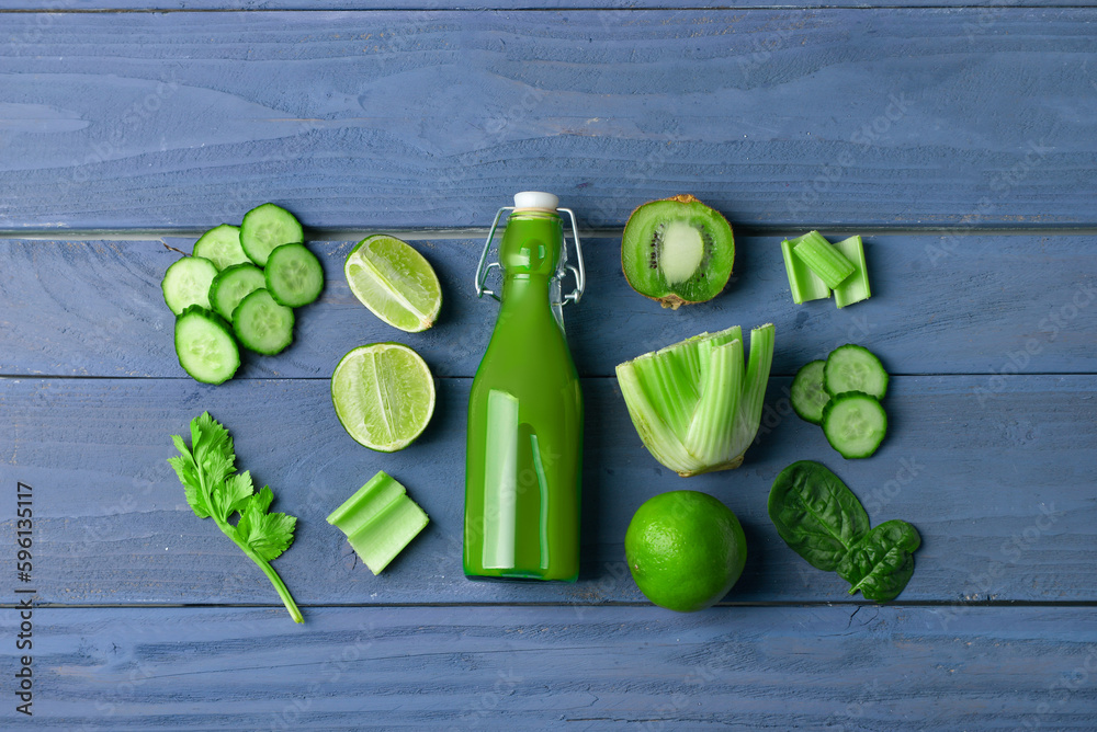 Glass of tasty green juice on blue wooden background