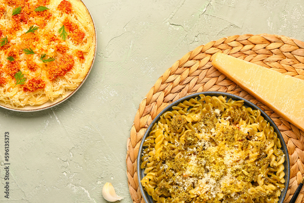 Plates of tasty Italian pasta with Parmesan cheese on light background