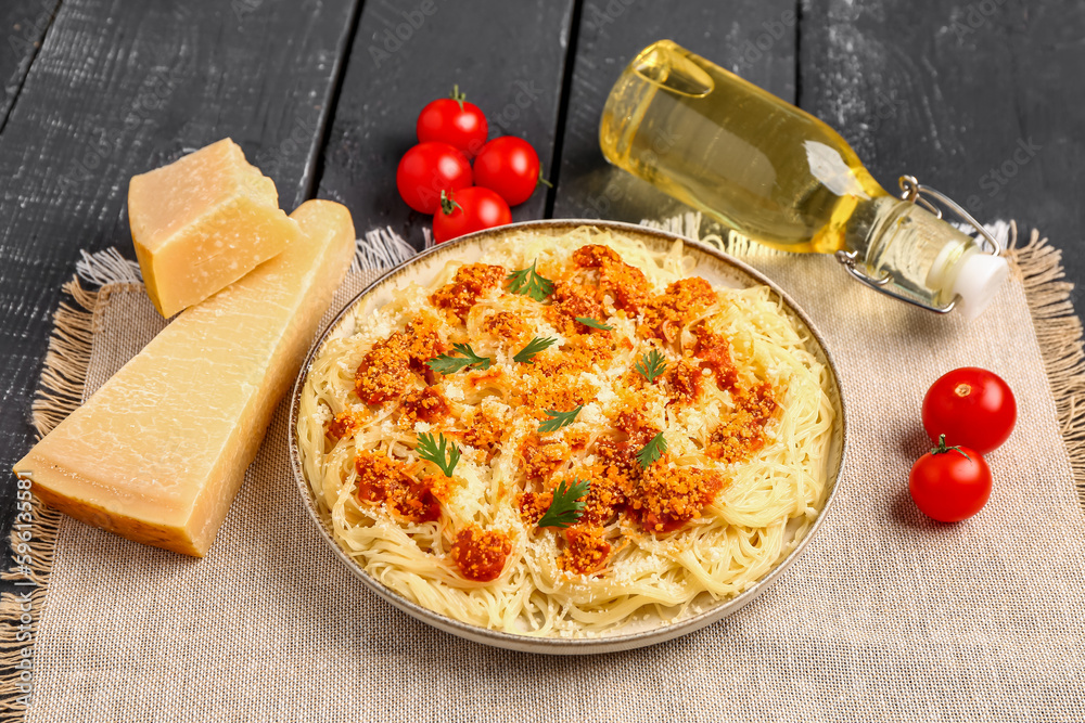 Plate of tasty Italian pasta with Parmesan cheese on dark wooden background