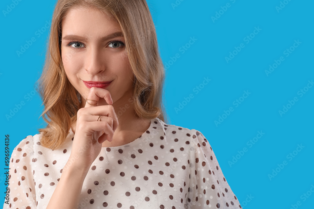 Thinking young woman on blue background, closeup