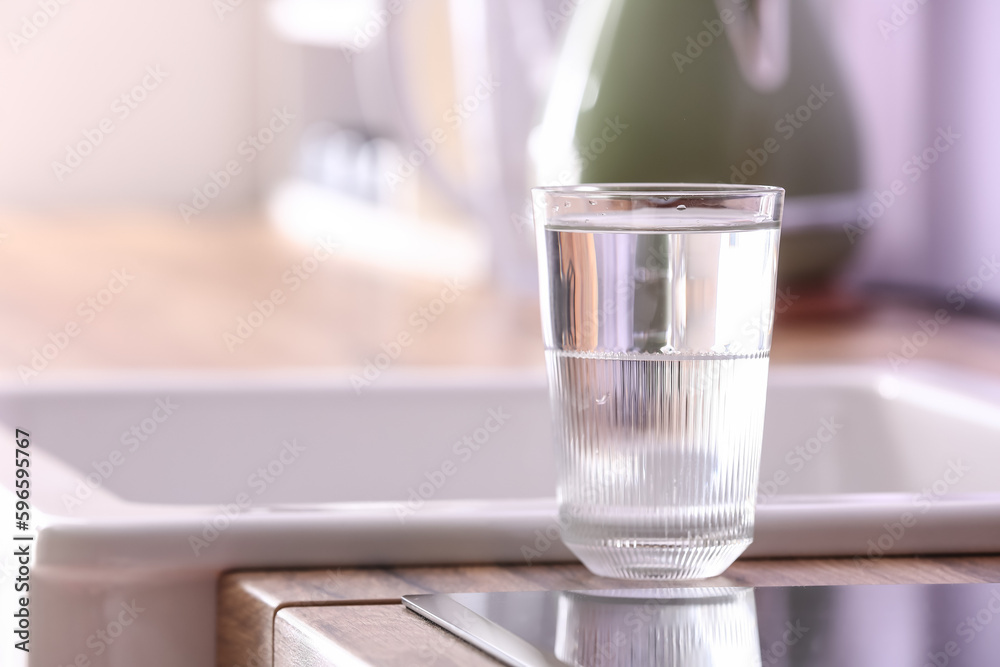 Glass of pure water on kitchen counter near sink, closeup