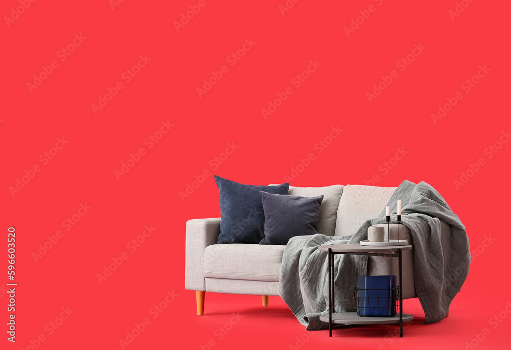 Cozy grey sofa and coffee table on red background