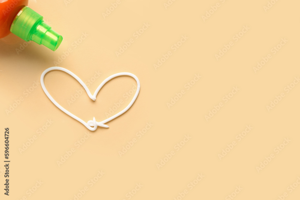 Sunscreen and heart made of cream on beige background