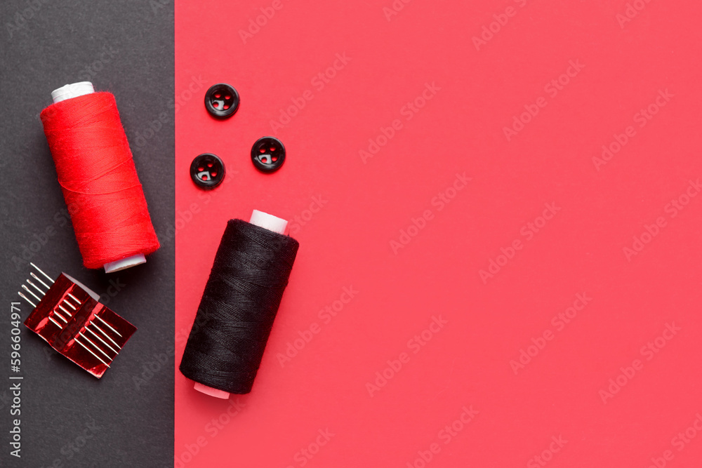 Composition with thread spools, buttons and needles on color background