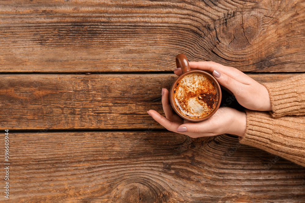 Woman with cup of coffee on wooden background