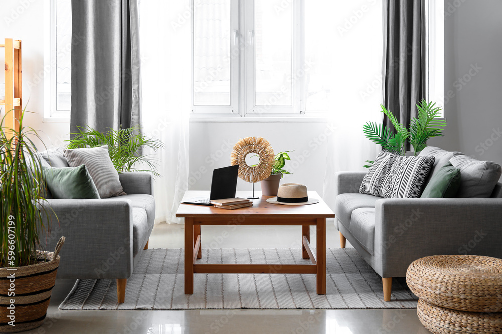 Interior of light living room with table and sofas