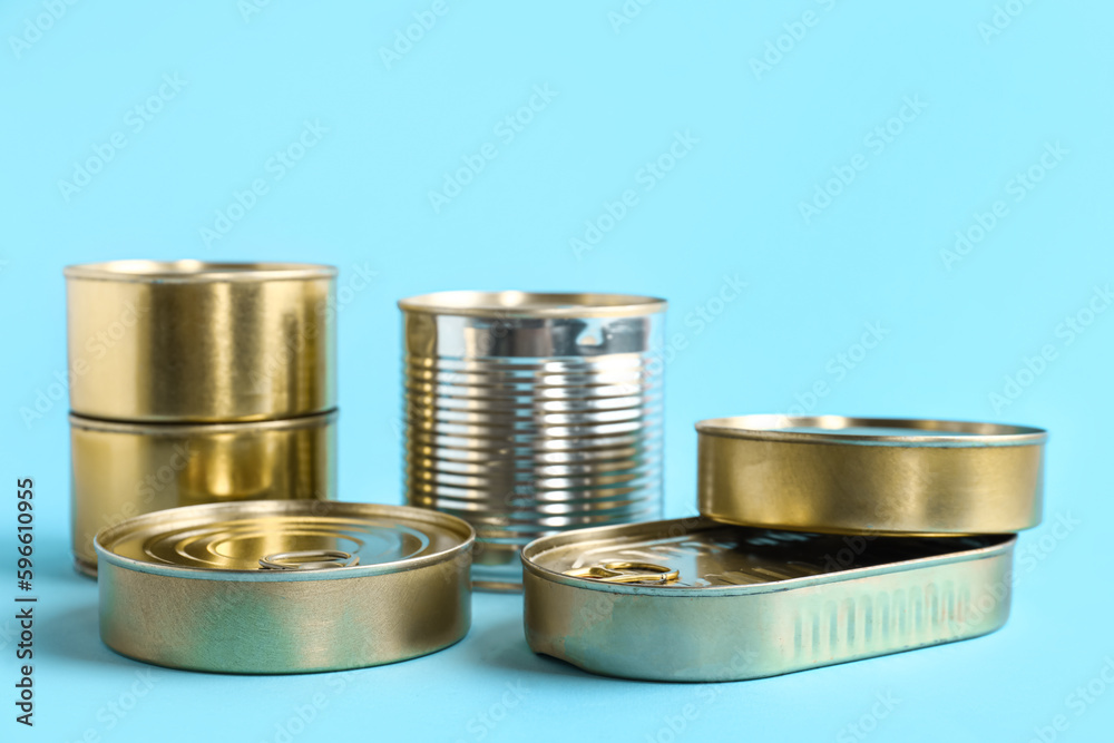 Tin cans with fish on blue background