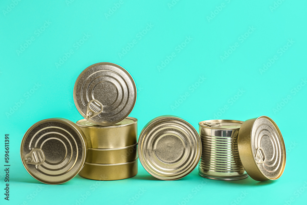 Tin cans with fish on turquoise background