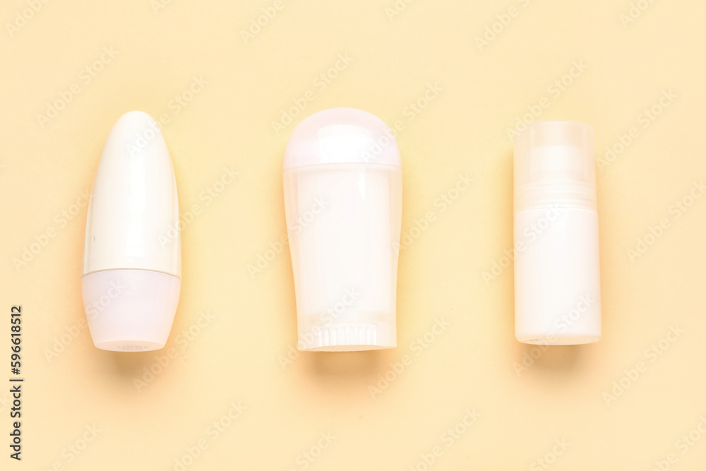 Different deodorant bottles on yellow background