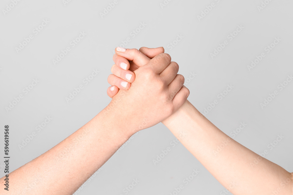 Women holding hands together on light background. Friendship concept