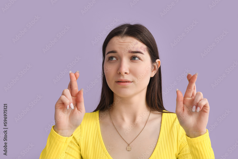 Young woman in bright shirt crossing fingers on lilac background, closeup