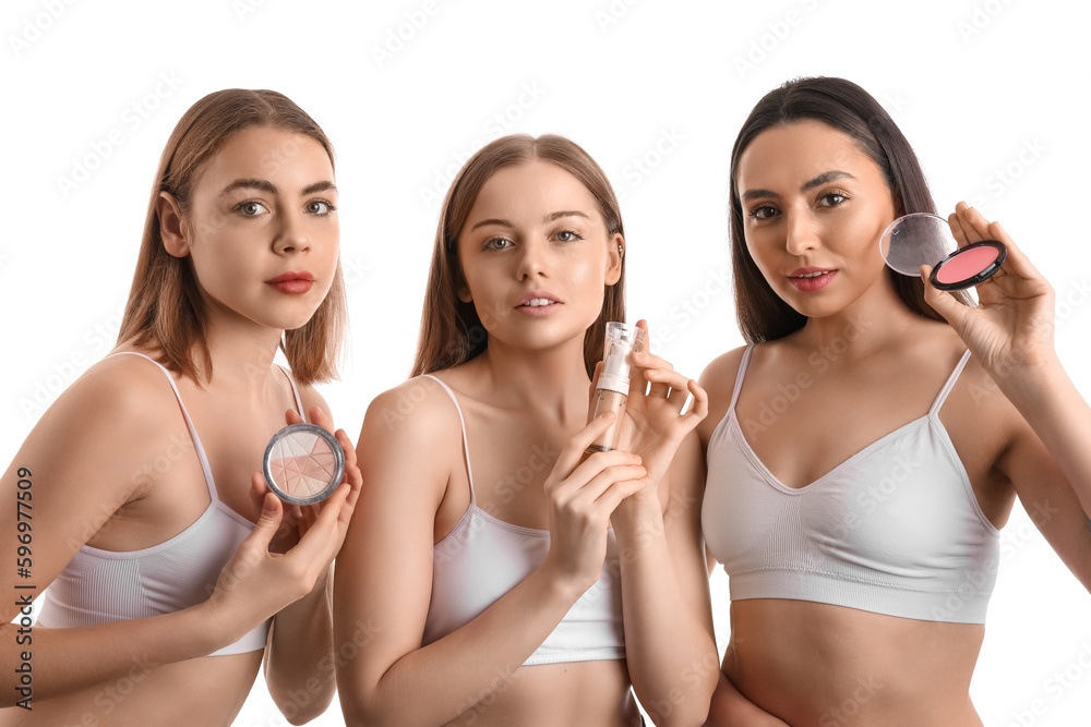 Young women with makeup products on white background