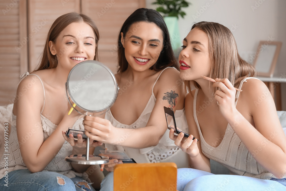 Young women doing makeup at home