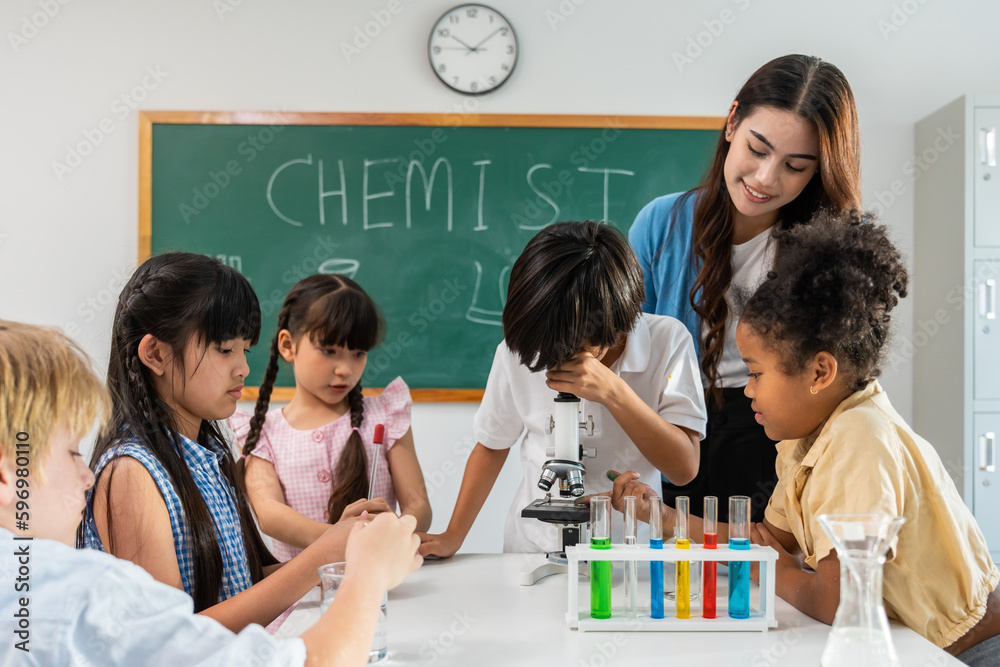 Adorable student learn with teacher in classroom at elementary school. 