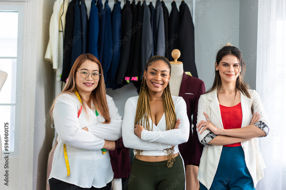 Portrait of diverse fashion designer work in tailoring atelier in store. 