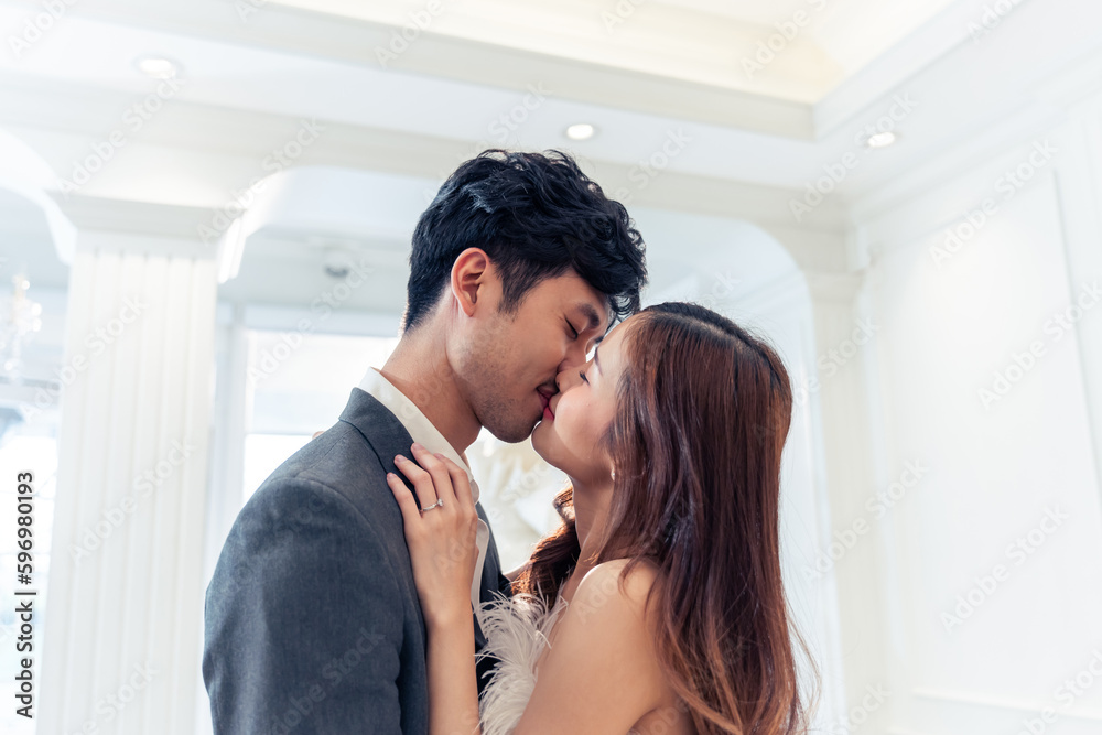 Asian attractive fiance couple kissing each other in wedding studio. 