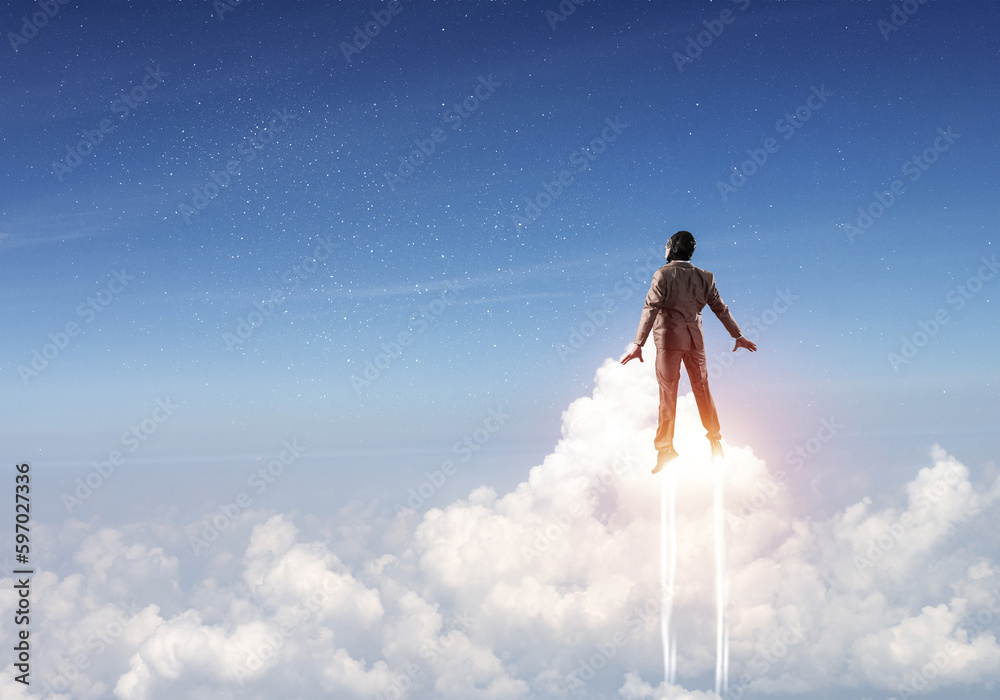 Businessman in suit and aviator hat flying in sky