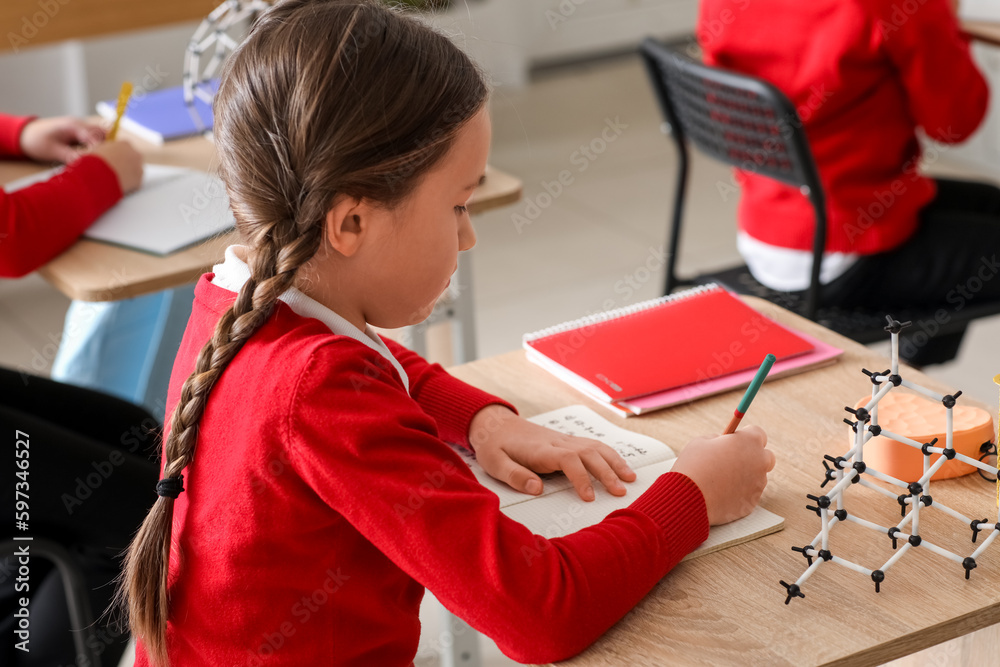 Little girl studying Chemistry lesson in science classroom, closeup