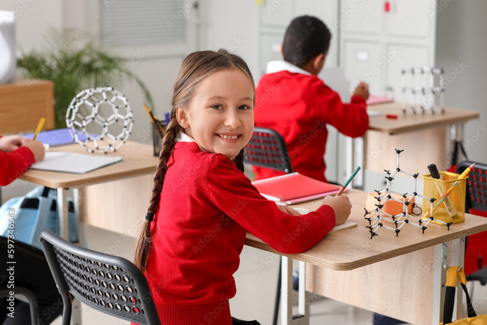 Little girl studying Chemistry lesson in science classroom