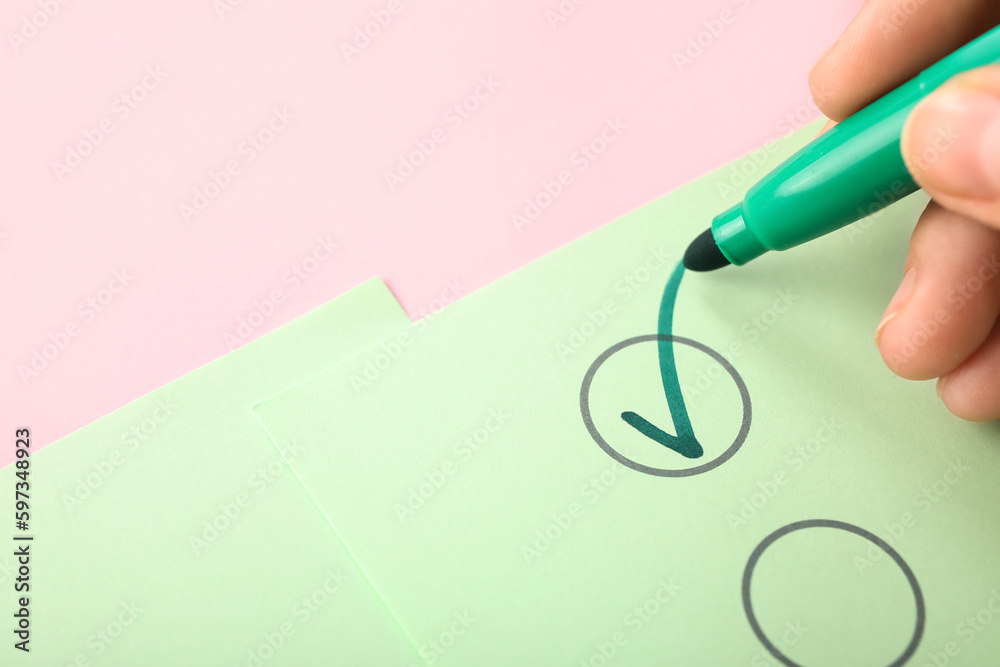 Woman marking on checklist box with green marker