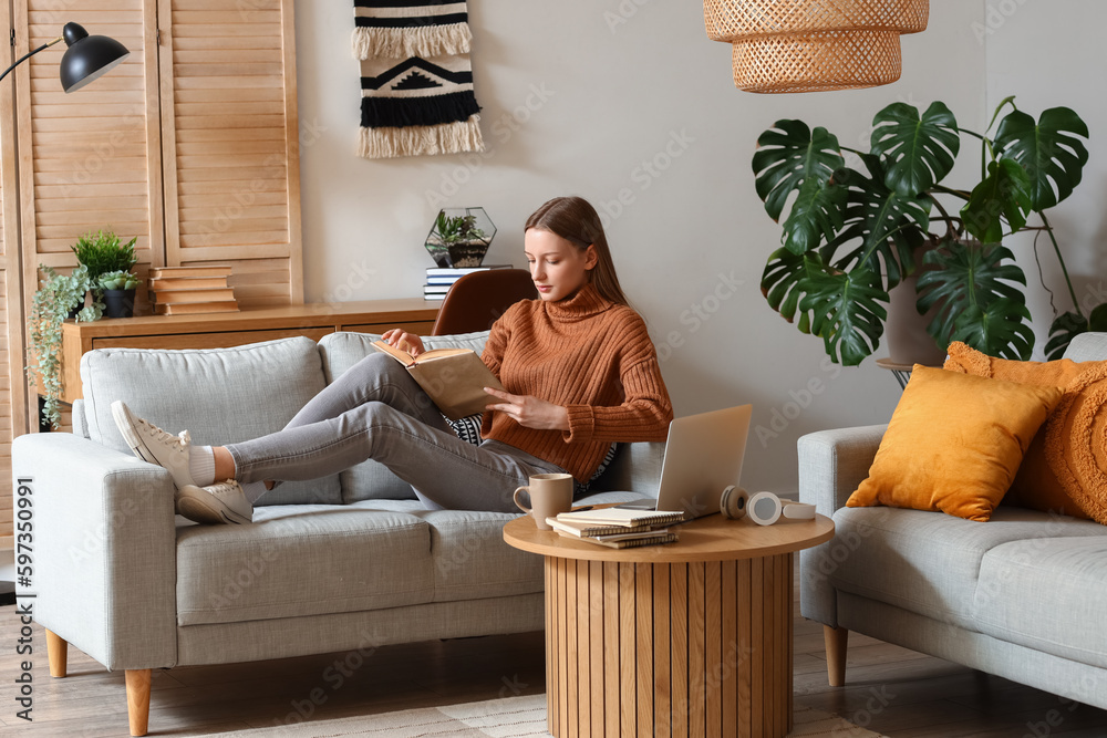 Female student reading book at home