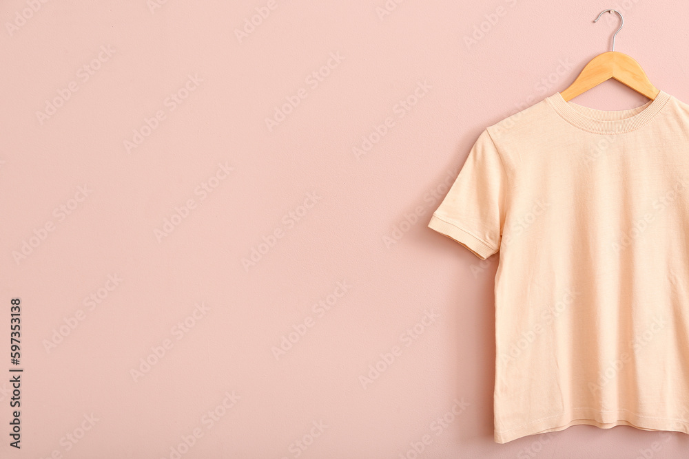 Stylish t-shirt hanging on pink wall