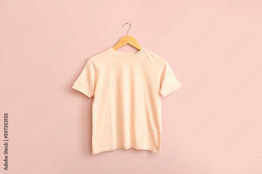 Stylish t-shirt hanging on pink wall