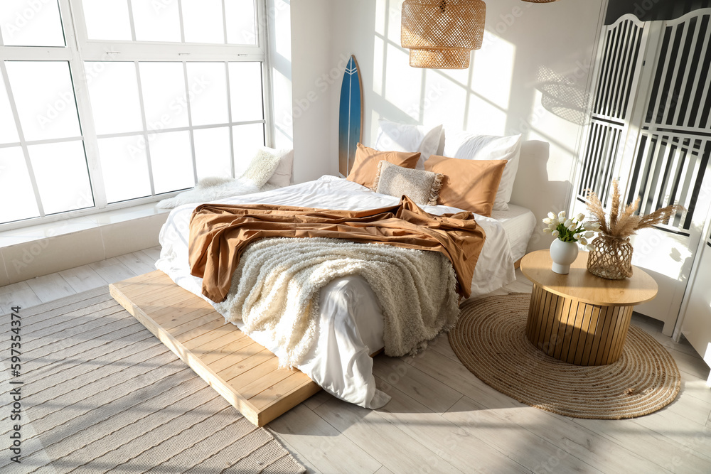 Interior of modern bedroom with surfboard and folding screen