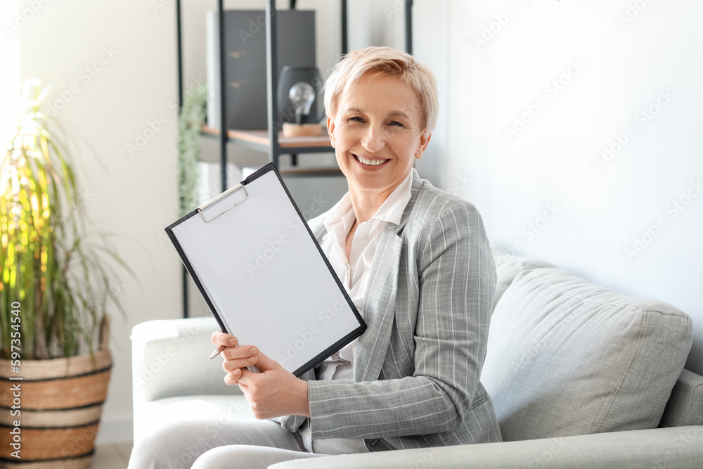 Mature businesswoman with documents in office