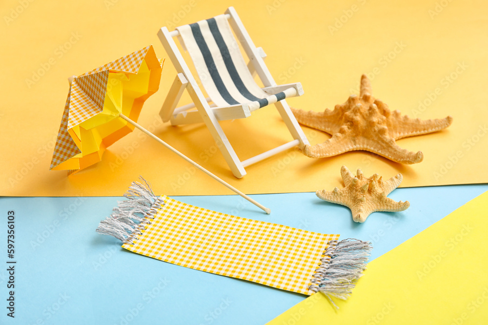 Composition with miniature deck chair, starfishes and paper umbrella on colorful background