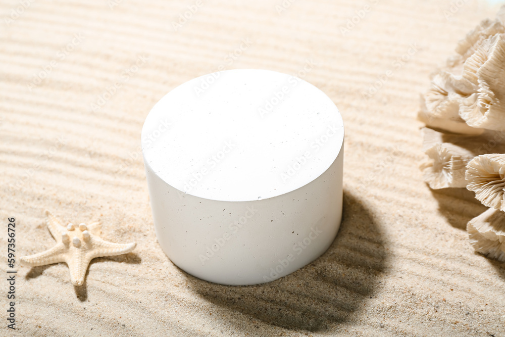 Decorative plaster podium, starfish and coral in sand